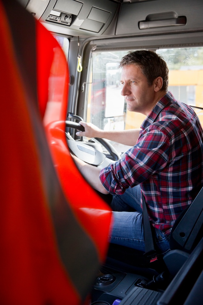Truck driver driving in cab of semi-truck