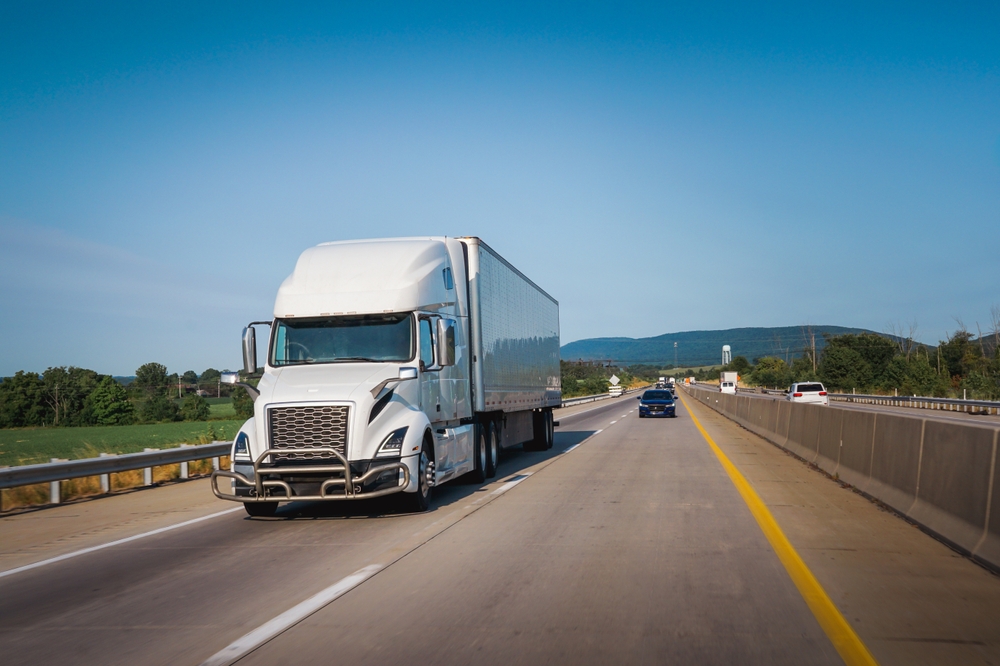 image of white 18 wheeler heading down the freeway from Redlands CA driven by a cdl trucker
